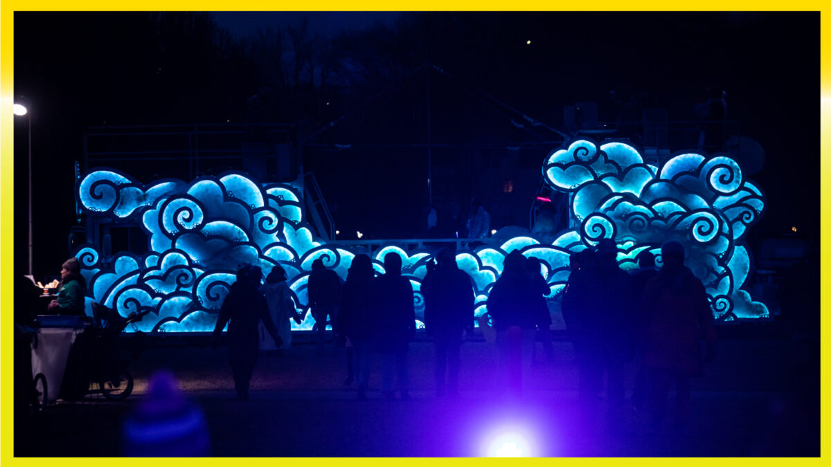 A bus in the dark covered in lights that are shaped like clouds.