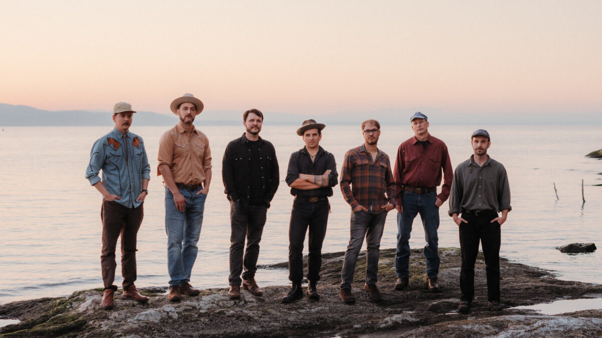 Photo of the band Ponyhustle, posing in front of a lake