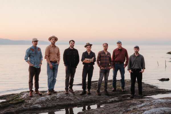 Photo of the band Ponyhustle, posing in front of a lake