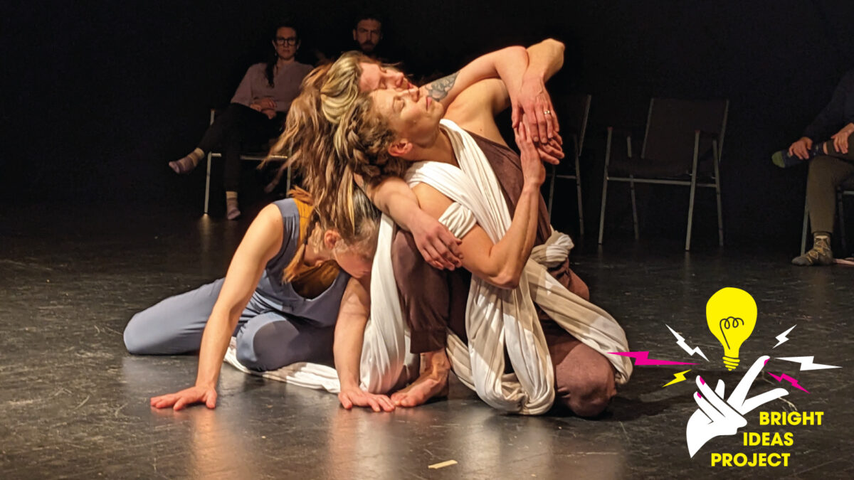 Photo of performers dancing on the ground together.